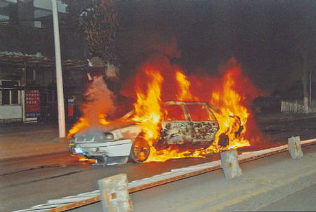 Một chiếc xe bị đốt ph trn đường phố Urumqi trong vụ bạo loạn đm chủ nhật. Ảnh: Xinhua.