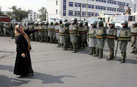 Một phụ nữ người dn tộc Duy Ng Nhĩ biểu tnh trước hng ro cảnh st c vũ trang tại Urumqi. Ảnh: